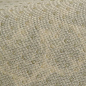 May include: Close-up of a textured fabric with a repeating pattern of small, raised dots. The fabric has a light beige color with subtle variations and a ribbed texture. The dots are a slightly darker shade.
