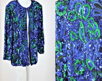 May include: A blue and green sequined jacket with a long sleeve and open front. The jacket is covered in a pattern of sequins in shades of blue and green.