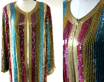 May include: A long-sleeved sequined jacket with a vertical striped pattern in gold, turquoise, pink, and burgundy. The jacket has a front zip closure.