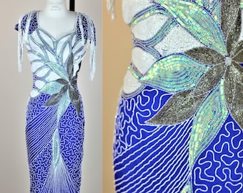 May include: A blue sequined dress with a white and silver floral design. The dress has a fitted silhouette and short sleeves.