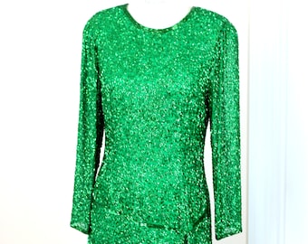 May include: A green sequined dress with long sleeves and a round neckline.