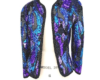 May include: A vintage sequined jacket in shades of purple, blue, and black. The open-front jacket is displayed on a mannequin. The sequins create a shimmering effect, and the jacket has long sleeves.