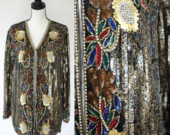 May include: A gold sequined jacket with a floral design featuring brown, red, blue, and green embroidery. The jacket has a zipper closure and long sleeves.