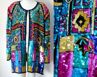 Puede incluir: Una chaqueta larga de lentejuelas con un patrón geométrico en tonos de azul, rosa, verde y dorado. La chaqueta tiene un ribete negro y un cierre frontal.