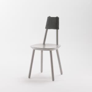 Puede incluir: Una silla de madera gris claro con un respaldo de tela gris. La silla tiene cuatro patas y un asiento ligeramente curvado.