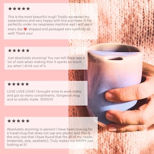 May include: A close-up of a hand holding a light blue and pink ceramic mug. The mug has a unique shape and a smooth, glossy finish. The background is a soft pink knitted fabric.