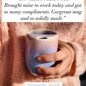 May include: A hand holding a light blue and pink ceramic mug with a unique shape. The mug has a smooth, glazed finish and a slightly rounded bottom. The caption reads: "LOVE, LOVE, LOVE! Brought mine to work today and got so many compliments. Gorgeous mug and so solidly made." -Samantha, Seattle
