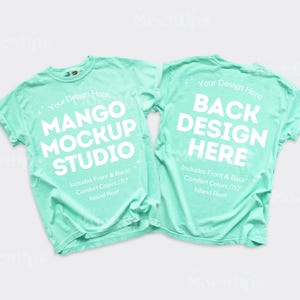 Może przedstawiać: Dwie jasnozielone koszulki, jedna z napisem "MANGO MOCKUP STUDIO", druga "BACK DESIGN HERE" w kolorze białym. Koszulki to Comfort Colors 1717 Island Reef.