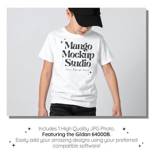 May include: A white t-shirt with the text "Mango Mockup Studio" in a black, bold font. The shirt is worn by a person wearing a black baseball cap and dark jeans. The image is a mockup for design software.