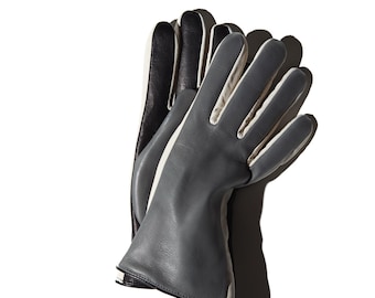 May include: A pair of leather gloves in a modern design. The gloves are primarily gray with white and black accents. The fingers and the outer edges of the gloves are gray, while the inner edges are white. The back of the gloves are black.