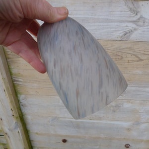 Pode incluir: Um abajur de cerâmica cinza claro com um padrão manchado de veios marrons e azuis.