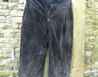Puede incluir: Un pantalón de pana negro con cierre de botón y un solo botón en la cintura.