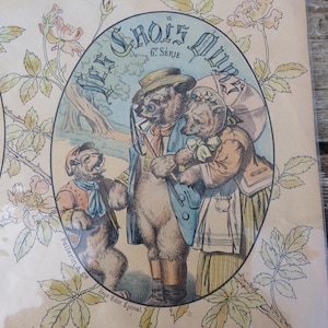 May include: Antique print featuring a family of bears in vintage attire. The illustration, set within an oval frame, showcases a father bear in a blue coat, a mother bear with a parasol, and a young bear. The background includes floral and foliage elements.