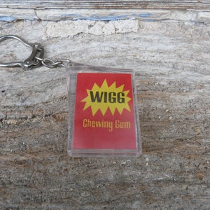 Puede incluir: Un llavero rojo y amarillo con las palabras "WIGG Chewing Gum" en él.