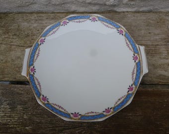 Op de afbeelding: Een witte achthoekige serveerschaal met een blauwe en gouden rand en roze bloemmotieven.