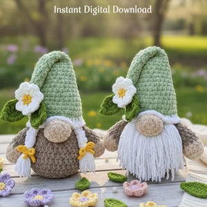 May include: Two crocheted gnomes with green hats, white beards, and tan bodies. Each gnome has a white flower with a yellow centre and green leaves. The text "Instant Digital Download" is at the top. Crocheted flowers and leaves are scattered around the gnomes.