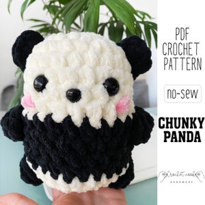 May include: A crochet pattern for a no-sew chunky panda. The pattern is available as a PDF download. The panda is white with black ears and eyes, and pink cheeks.
