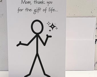 May include: A white card with black text that reads "Mom, thank you for the gift of life..." and a stick figure drawing with a star above its head.