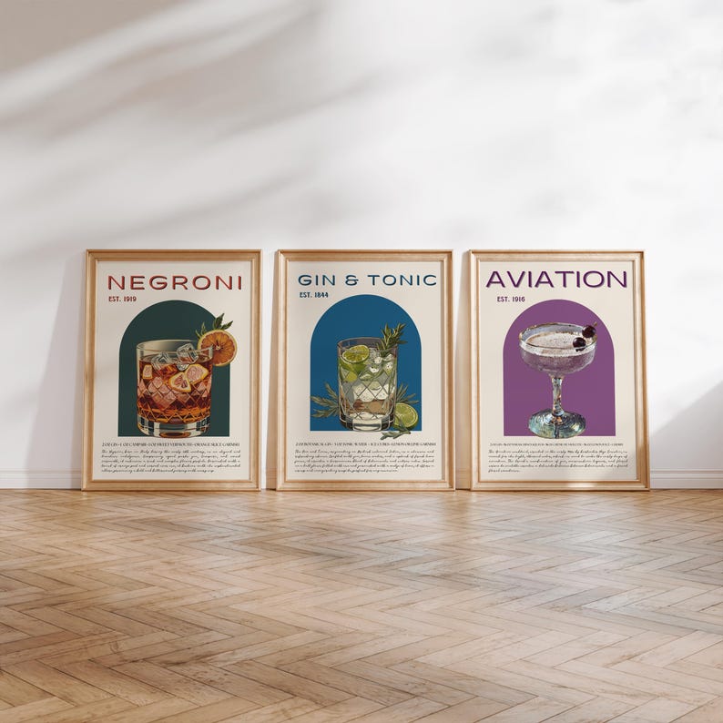 May include: Three vintage-style cocktail posters with illustrations of a Negroni, Gin & Tonic, and Aviation. Each poster features a colorful archway with the drink's name and establishment date.