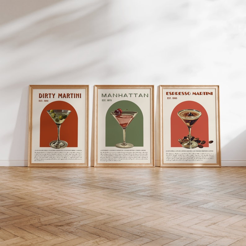 May include: Three vintage-style posters with illustrations of cocktails. The posters are framed in wood and have a white background. The first poster is for a Dirty Martini, the second for a Manhattan, and the third for an Espresso Martini.