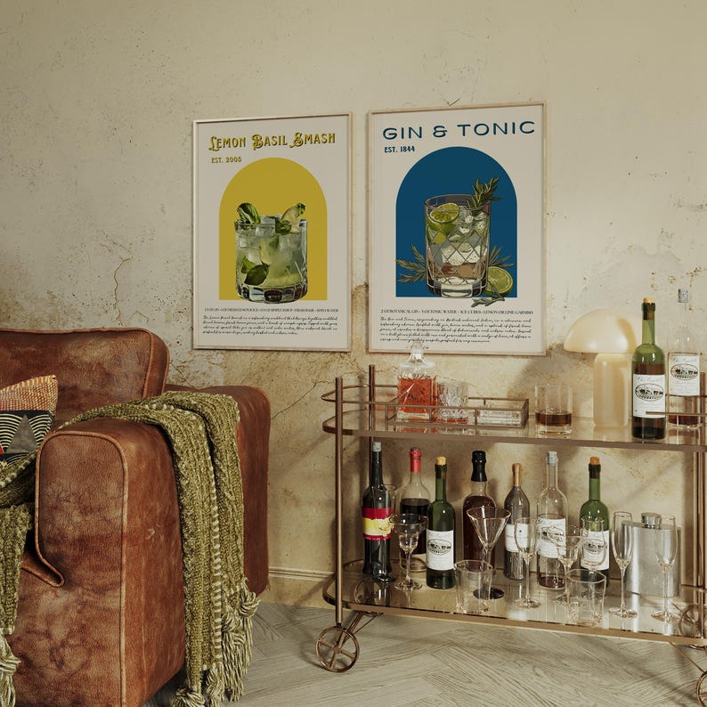 May include: Two vintage-style posters with illustrations of cocktails. The posters are framed and hanging on a wall. The posters are titled "Lemon Basil Smash" and "Gin & Tonic".