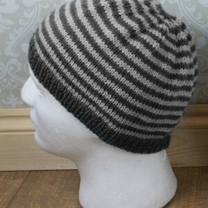 May include: A gray and white striped knit beanie hat.