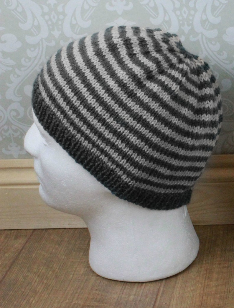 May include: A gray and white striped knit beanie hat.