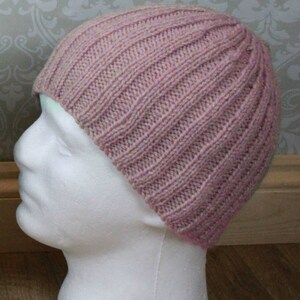 May include: A pink knitted beanie with a ribbed texture.