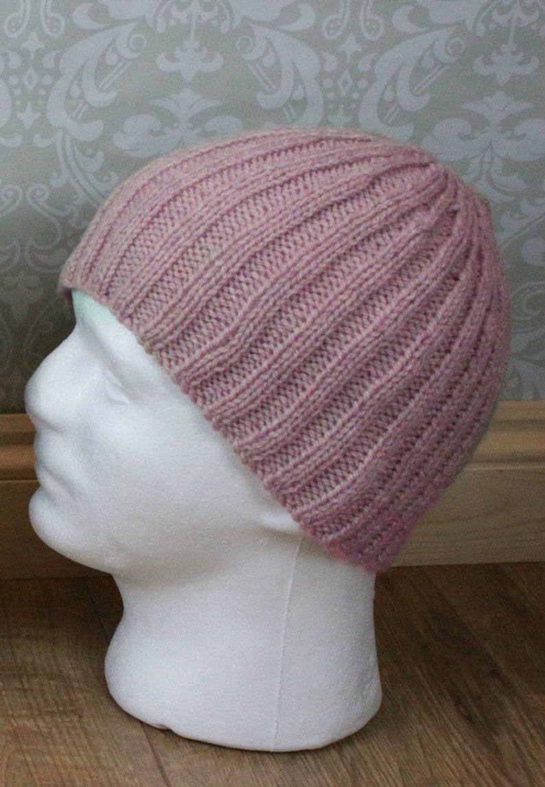 May include: A pink knitted beanie with a ribbed texture.