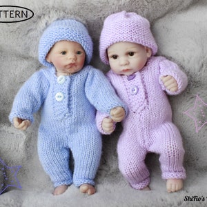 May include: Two knitted baby doll outfits, one in light blue and one in lilac, with matching hats. The outfits feature button fastenings and are made with a soft, textured yarn.