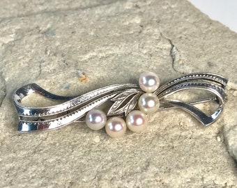 Mikimoto Silver bar brooch featuring 5 exquisite Japanese Akoya Pearls. Signed.