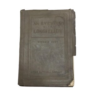 May include: A vintage book titled "An Evening with Longfellow" by Sherwin Cody. The book is bound in brown leather with gold lettering and is part of the "Home Library" series.