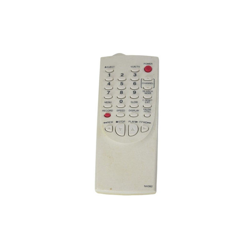 May include: A white remote control with a red power button and a variety of buttons for controlling a television or VCR. The buttons include numbers, channel up and down, menu, record, play, stop, rewind, fast forward, and more.