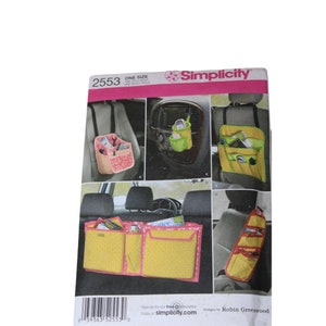 May include: Simplicity sewing pattern number 2553 for car organisers. The pattern includes instructions for making four different organisers: a seat back organiser, a console organiser, a seat back organiser with multiple pockets, and a seat back organiser with a hanging strap. The pattern is for one size.