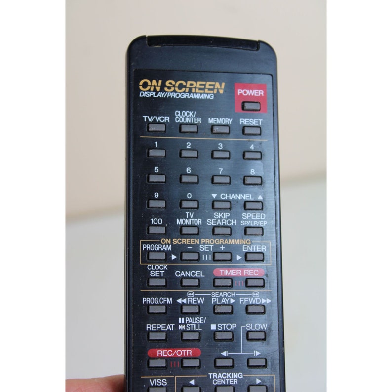 May include: Black remote control with a variety of buttons, including "On Screen Display/Programming", "TV/VCR", "Clock/Counter", "Memory", "Reset", "Channel", "Skip", "Speed", "Monitor", "Search", "Program", "Set", "Enter", "Clock", "Cancel", "Timer Rec", "Search", "Prog.CFM", "REW", "Play", "FFWD", "Pause/Still", "Stop", "Slow", "REC/OTR", "VISS", and "Tracking Center".
