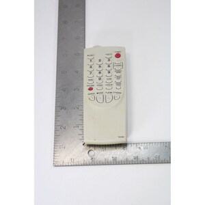 May include: A white remote control with a red button labeled "Power". The remote has a number pad, directional buttons, and buttons for "Menu", "Record", "Speed", "Display", "Clock", "Direct", "Pause", "Exit", "Channel", "Blanket Mode", "Volume", and "A/Select". The remote has the model number "NA362" printed on the bottom.