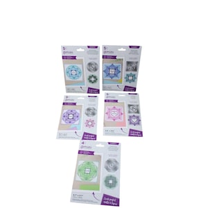 Peut inclure: Cinq paquets de matrices de découpe pour la création de cartes avec des motifs différents. Chaque paquet a un fond violet avec le mot "Gemini" et le nombre de matrices incluses. Les matrices sont de différentes couleurs et motifs, y compris des formes géométriques, des cœurs et des motifs floraux. Les paquets sont étiquetés "Card perfect mats & layers".