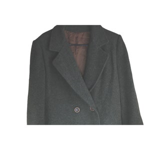 May include: A dark green double-breasted wool coat with a brown lining and two buttons.