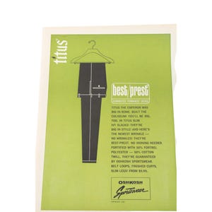 May include: Vintage advertisement for Titus slim Ivy slacks by Oshkosh Sportswear. The ad features a drawing of black pants hanging on a hanger against a green background. Text includes "best/prest" and "guaranteed permanent crease."