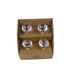 May include: Four clear, faceted crystal cabinet knobs, diamond-shaped, presented in a cardboard box. The knobs have a reflective surface. The box is labelled "Instant Furniture Update" and "Set of 4 Drawer Knobs".