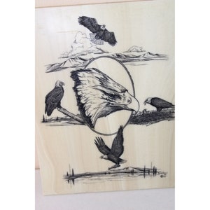 May include: A black and white pen and ink drawing of bald eagles on a wood panel. The drawing features a close-up of an eagle's head in an oval frame, with other eagles flying and perched on branches. The artist's signature and date are in the lower right corner.