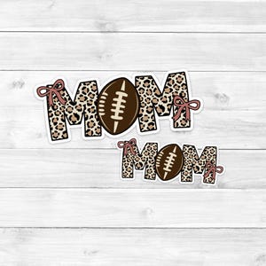 May include: Two vinyl stickers with a leopard print design and a football in the center. The top sticker says "MOM" and the bottom sticker says "MOM".