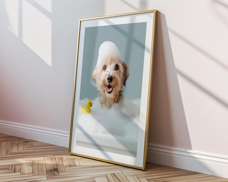 May include: A framed print featuring a happy dog in a bubble bath with a yellow rubber duck. The dog has a foamy bubble hat and is smiling. The frame is gold, and the background is a light blue.