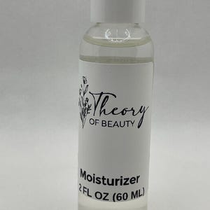 May include: A clear plastic bottle with a white cap, containing a clear liquid. The label reads "Theory of Beauty" with a floral design and "Moisturizer 2 FL OZ (60 ML)".