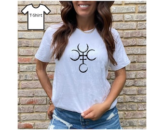 May include: White t-shirt with a black graphic design. The design features a stylized symbol with crescent moon shapes and vertical lines. The shirt is short-sleeved and worn by a person in blue denim shorts.