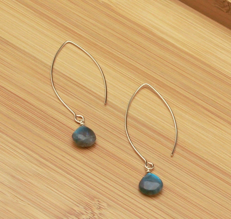 May include: A pair of silver dangle earrings with teardrop-shaped blue labradorite stones.