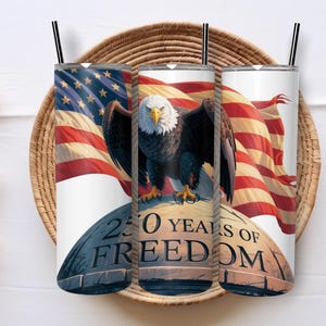 May include: Three white stainless steel tumblers with black straws, each featuring a patriotic design. The design includes an American flag, a bald eagle, and the text "250 YEARS OF FREEDOM."