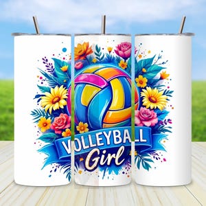 May include: A white tumbler with a colorful design featuring a volleyball, flowers, and the text "Volleyball Girl".