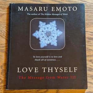 May include: A book titled "LOVE THYSELF" by Masaru Emoto. The cover is black with white text and a snowflake image. The book is part of "The Message from Water" series.
