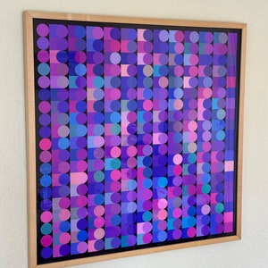 May include: A framed abstract art print featuring a geometric pattern of circles and squares in shades of purple, pink, and blue.